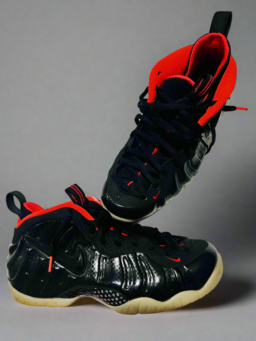 Black and red high-top sneakers on a white surface