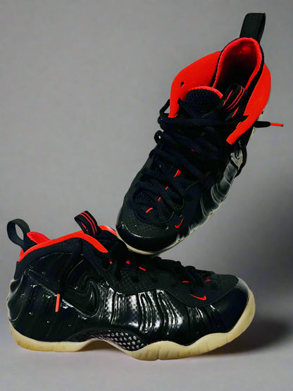 Black and red high-top sneakers on a white surface