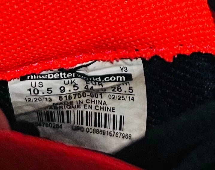 Close-up of a Nike tag on a red and black garment with text and numbers.