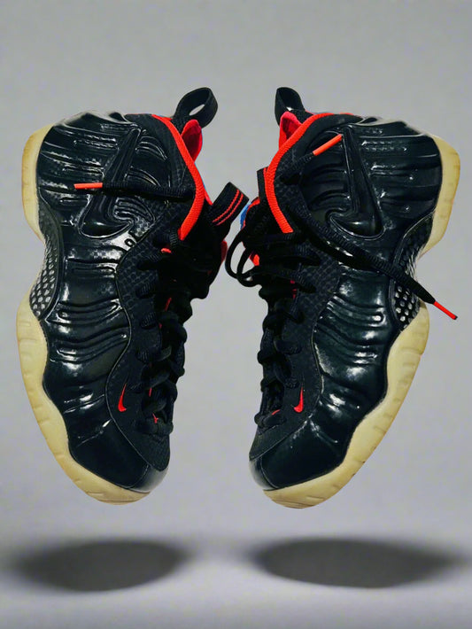 Black sneakers with red accents on a white background